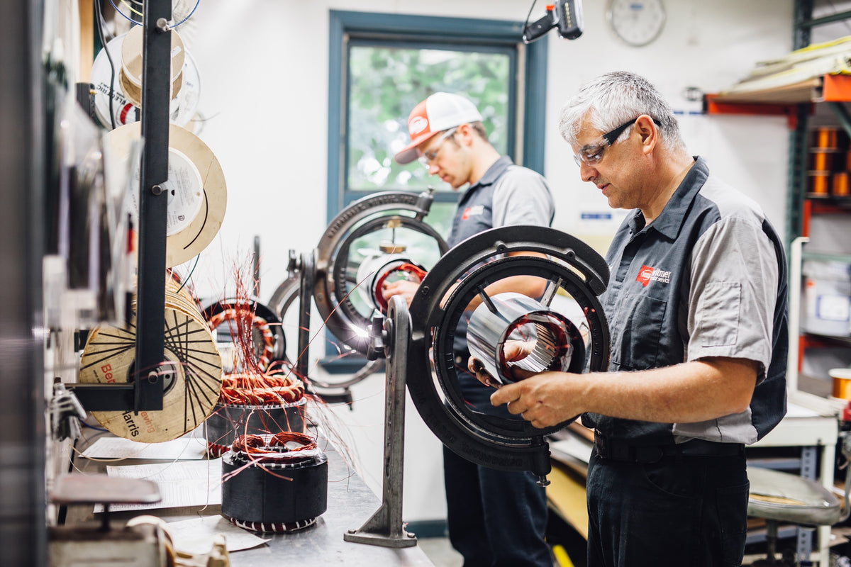 Vlad and Bradley inserting new copper coils into Electric Motors. Rewinding